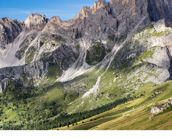 person walking on high mountain path - stepping out into a magnificent future